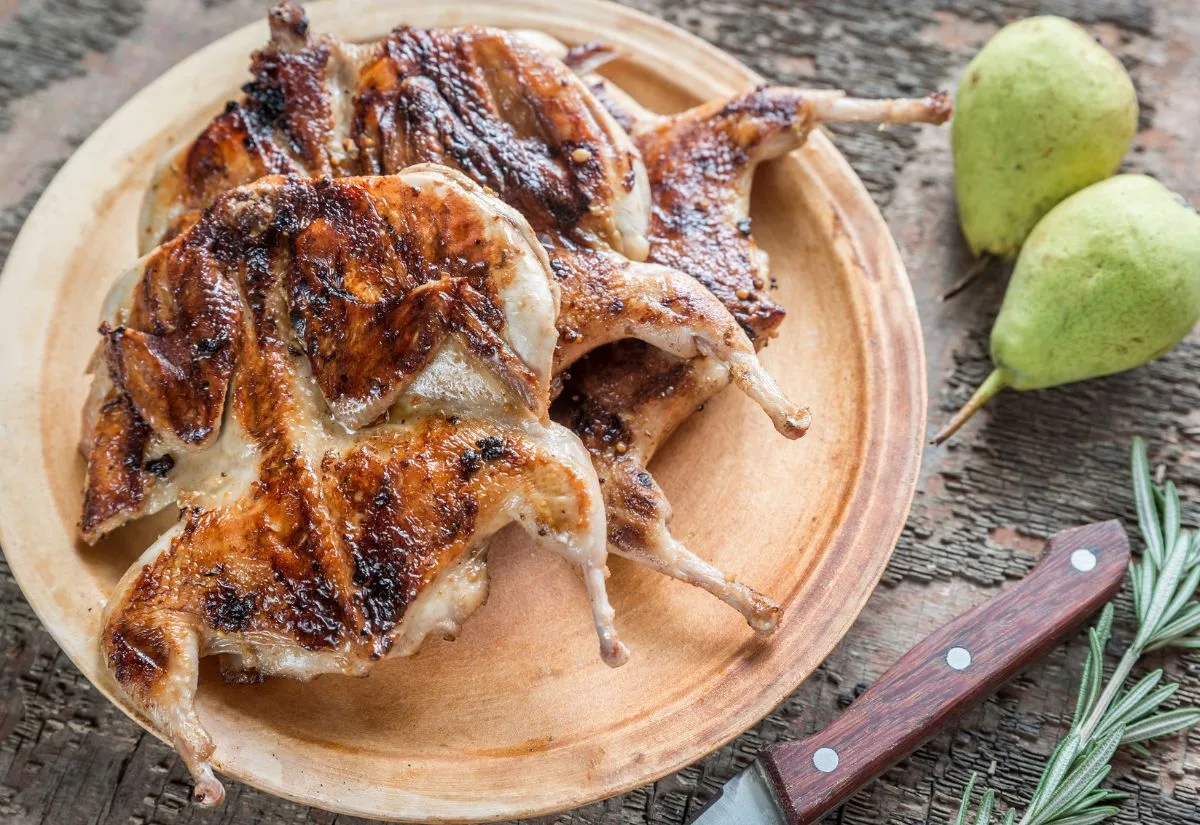 Spitcocked roasted quail on a plate.
