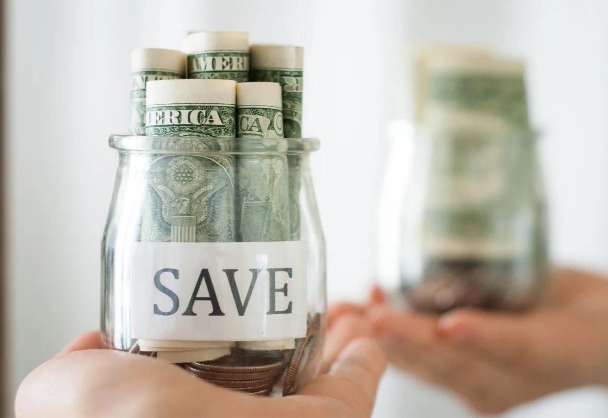 A jar with "save" written on it and filled with dollar bills.